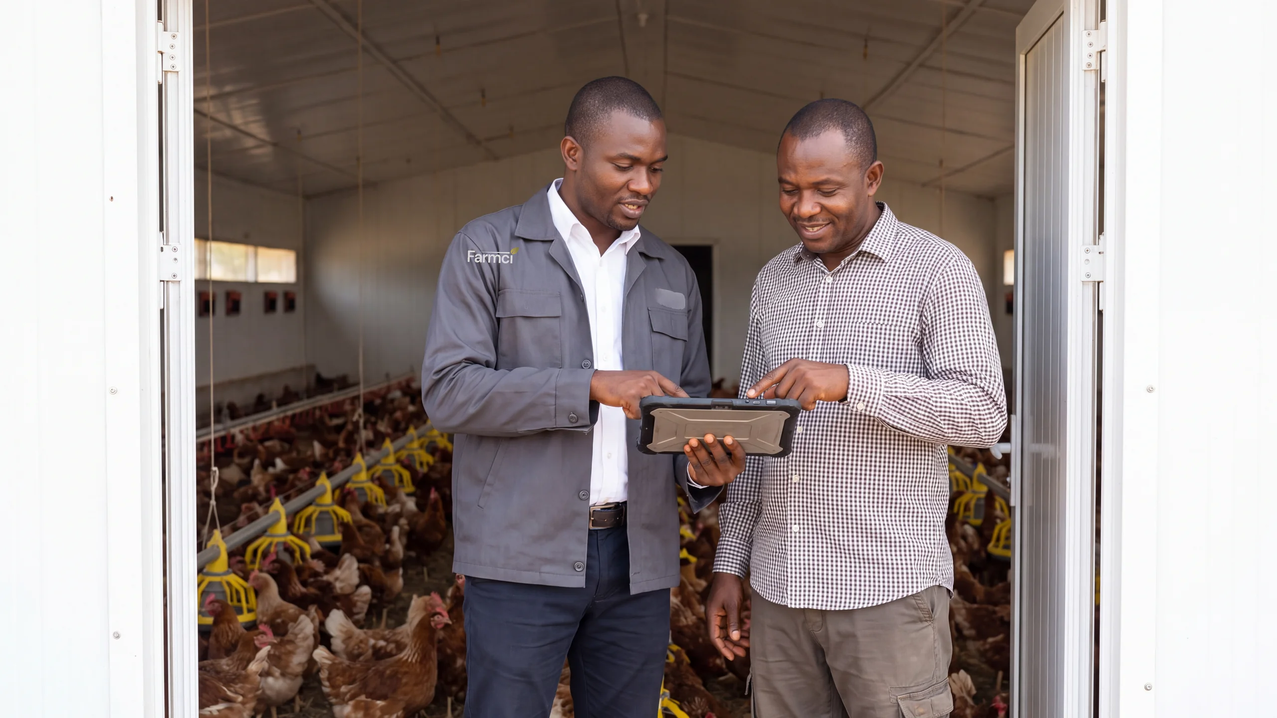 A Farmci field officer and a farm owner looking at a record together